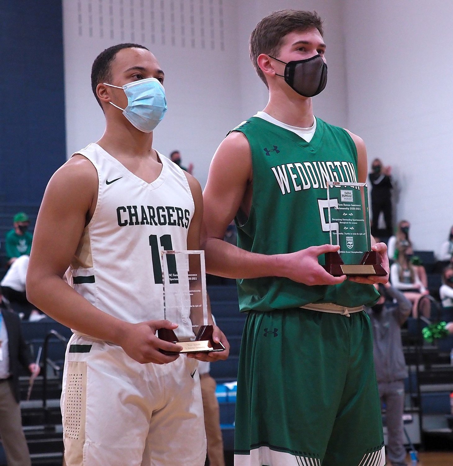 Northwood senior guard Troy Arnold (11) and Weddington senior center Caleb Wetherbee pose for photos after earning the NCHSAA's Sportsmanship Award prior to Weddington's 56-47 win over Northwood in the state title game on Saturday.